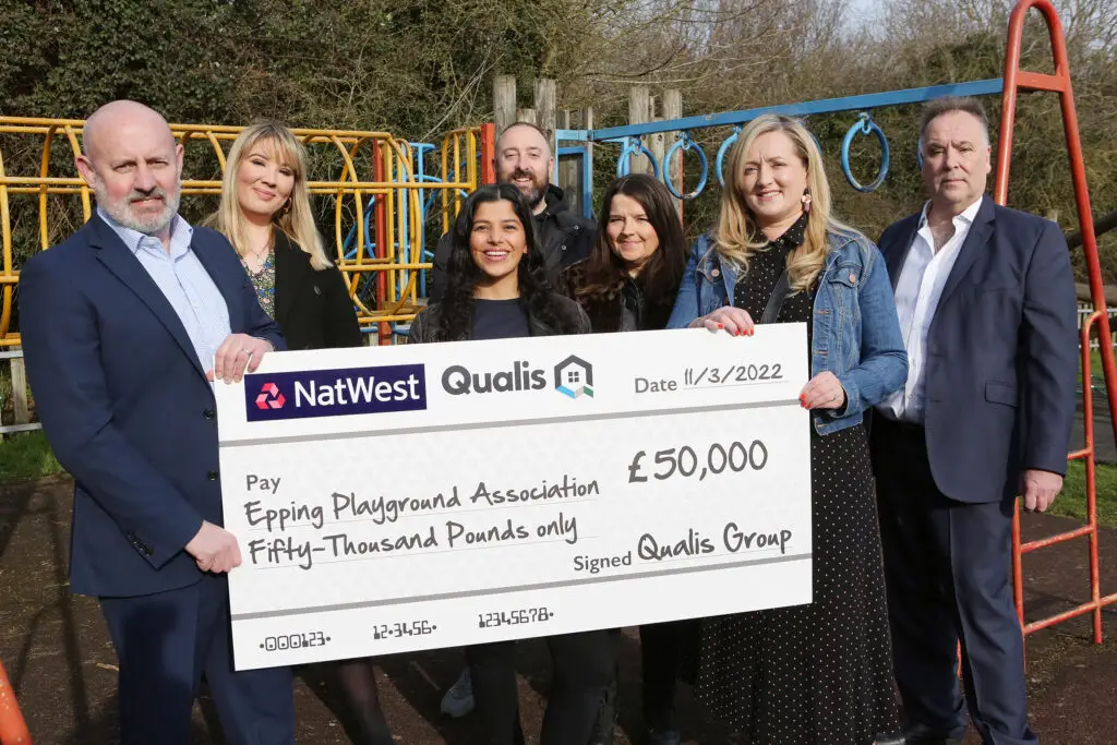 7 people in a playground holding a cheque for £50,000