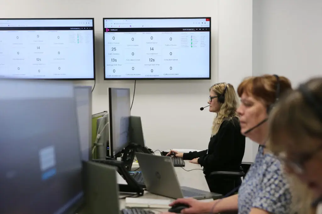 Employees on computers with headsets on in a call centre