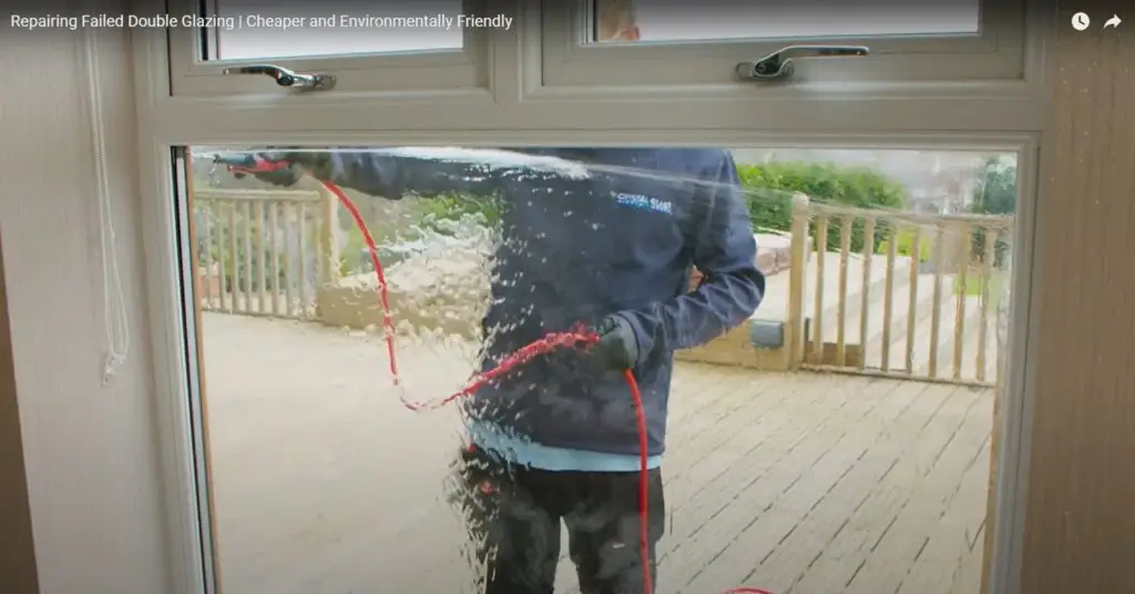 YouTube screenshot of a person using a hose to clean a window