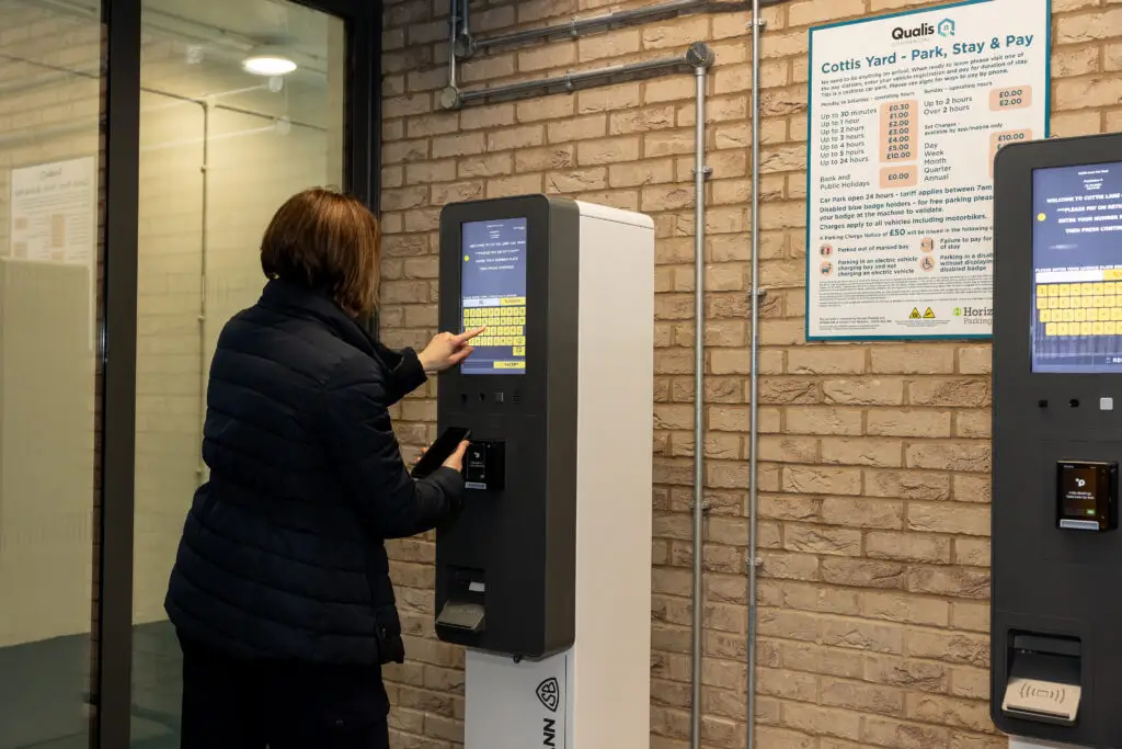 Person using a ticket machine at Cottis Yard Car Park