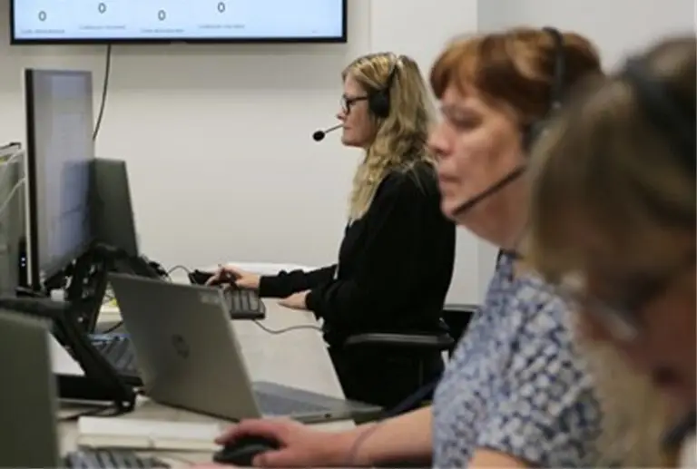 Employees on computers with headsets on in a call centre