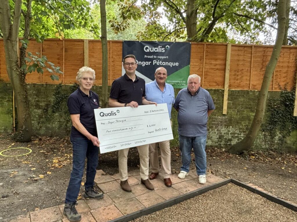 Four people stand in front of a giant cheque on ongar petanque playing ground