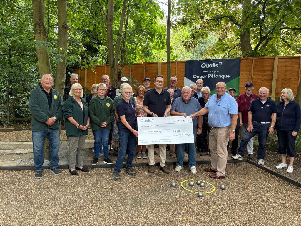 Group of petanque players stand holding a giant cheque