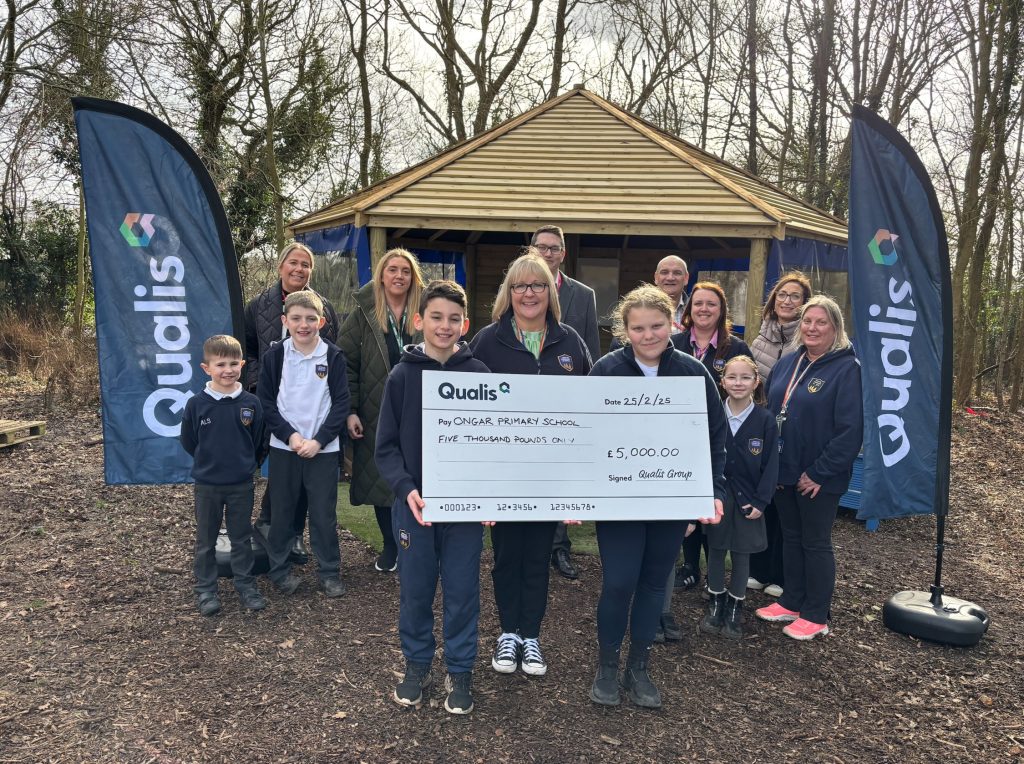 Community Benefit Fund recipients hold a giant cheque in front a wooden gazebo