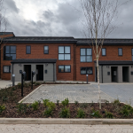 terraced houses with electric vehicle parking out front