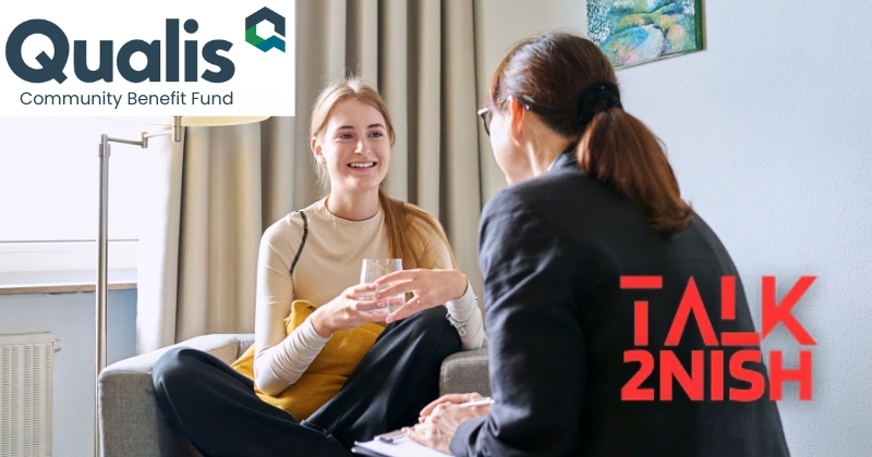Young female teenager talking with counselor, teacher sitting in chair in office